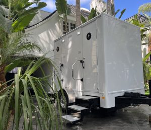 A portable restroom trailer rental set up at a private residence in San Diego, CA for a special event.