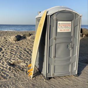 A porta potty rental set up on the sand in San Diego, CA.