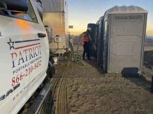 Patriot service truck pumping a portable toilet on the beach