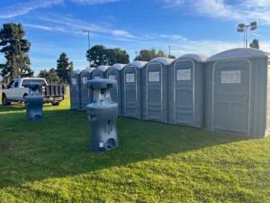 Row of portable toilets at an outdoor sports field