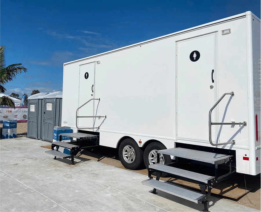 Patriot restroom trailer and portable toilets set up for an event