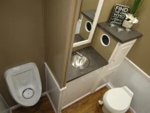 Interior of a Porta Lisa restroom trailer with toilet and shelf