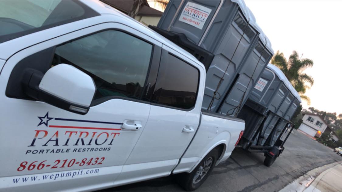 Patriot service truck loaded with portable toilets for delivery