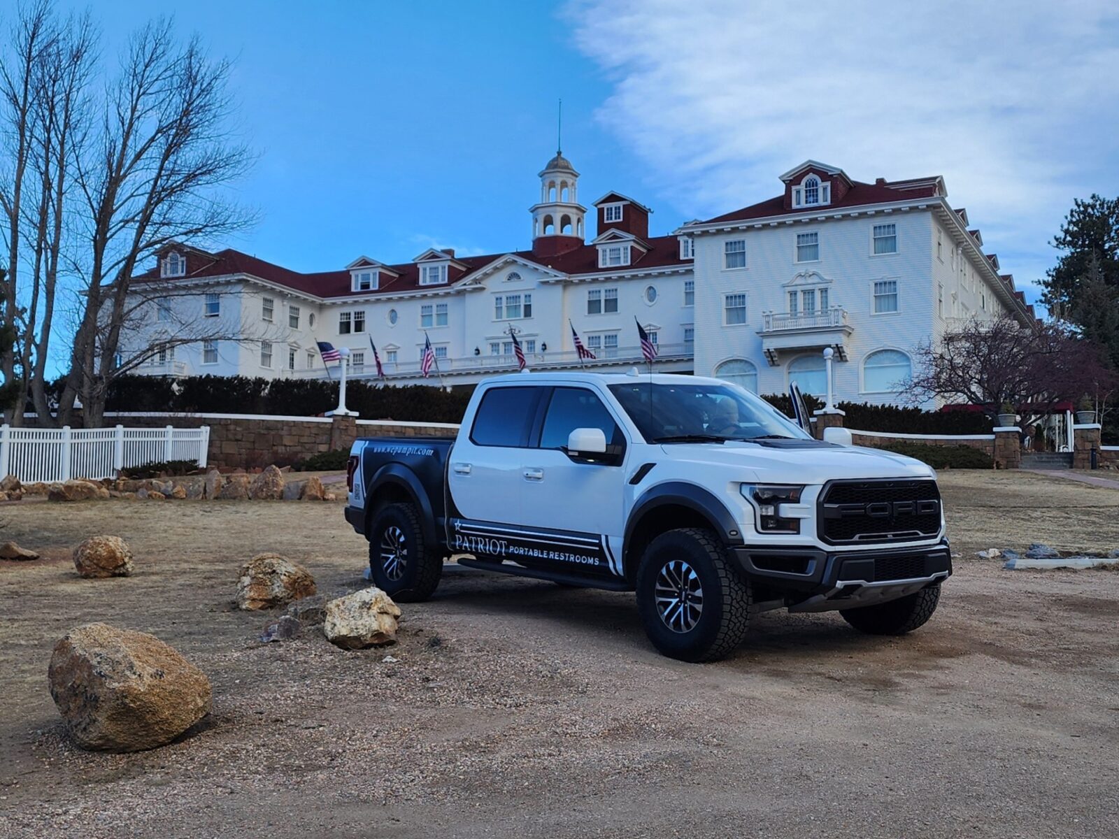 Patriot truck parked outside a historic hotel on a film location