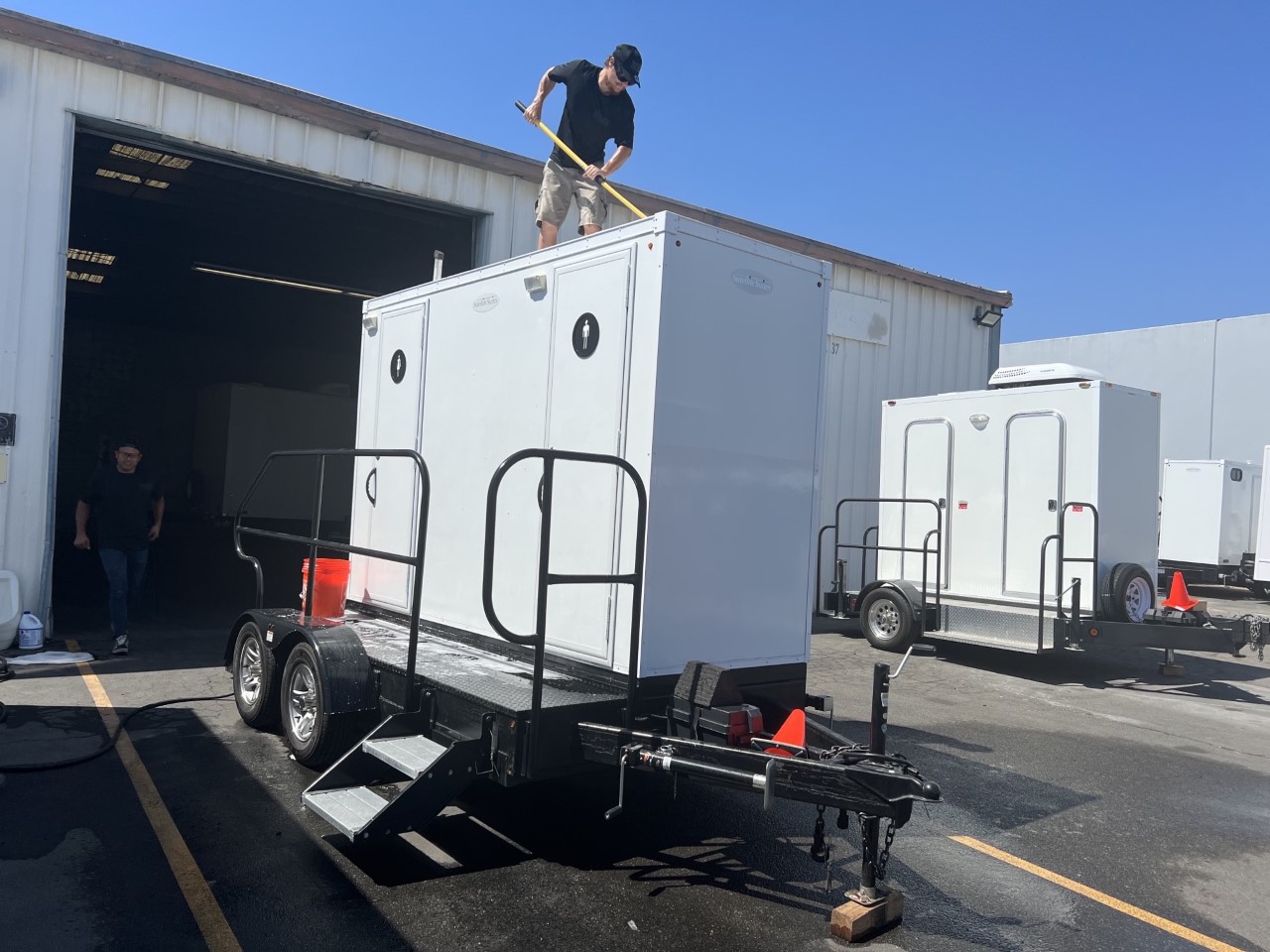 One of our employees cleaning the top of a 2-stall luxury portable restroom trailer.