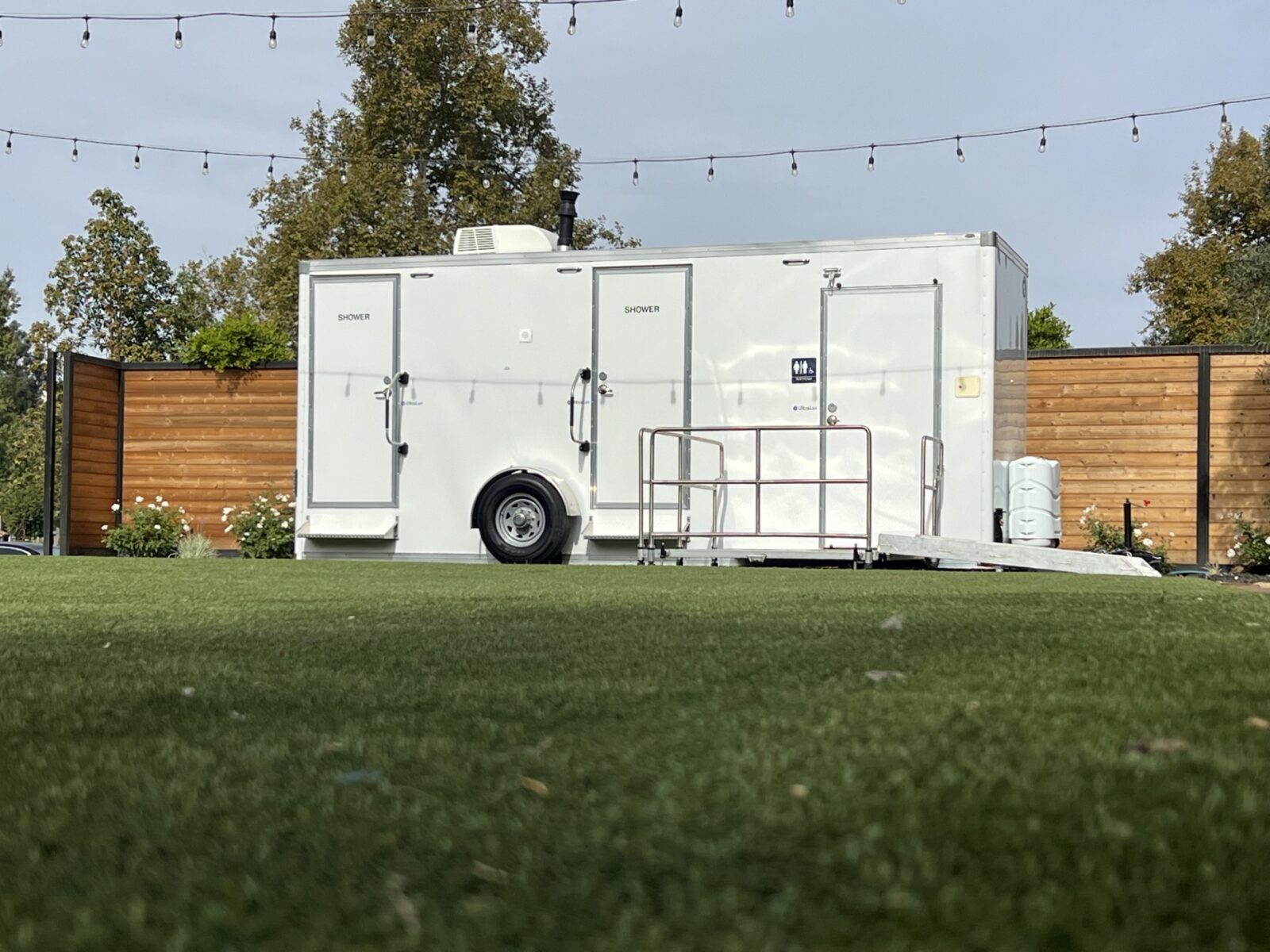 Patriot restroom trailer set up on grass for a wedding