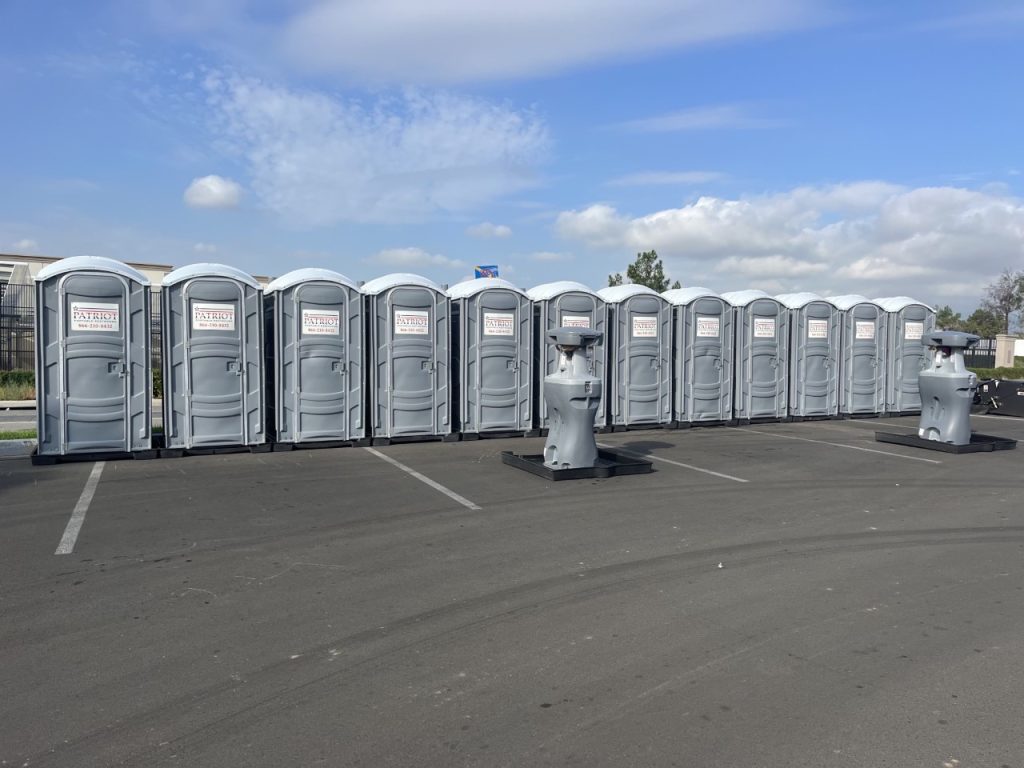 Row of portable toilets staged in a parking lot